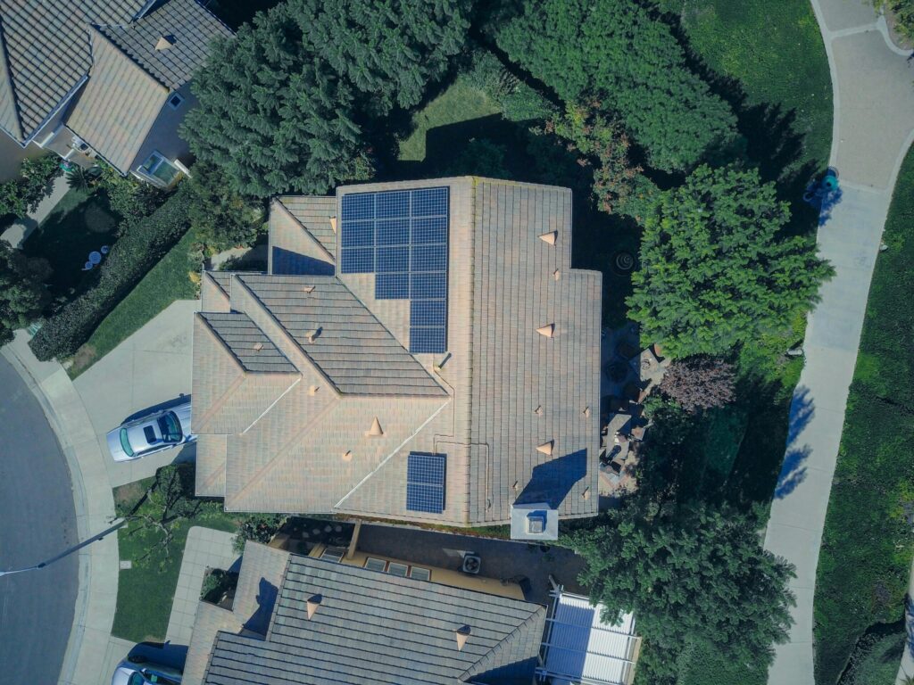 dachinstallation-photovoltaik-subunternehmer Photovoltaikinstallation durch einen erfahrenen Subunternehmer in Aargau. Luftaufnahme eines Hauses mit Solarmodulen von oben, das moderne Lösungen für erneuerbare Energien zeigt.